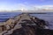 Pier / jetty of rocks covered in seaweed and beautiful sky, cala bona, mallorca, spain