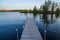 Pier jutting out into the Chippewa Flowage in front of a wooded island in the Northwoods