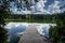 Pier on a lake with clouds reflected in the water. Located at Trap Pond State in Delaware