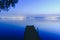 Pier on a lake at sunset with calm water and reflections of relaxing lights