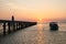 Pier landscape at sunset, people the going on a pier, happy people walking at the sea and observing a decline.