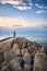 Pier with lighthouse protected by concrete breakwater tetrapods at sunset