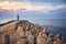 Pier with lighthouse protected by concrete breakwater tetrapods at sunset