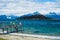 Pier located on a tranquil shoreline with a vibrant Flag of Argentina waving in the foreground