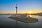 Pier with mast of navigation equipment and cargo berth of ships, sunrise