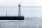 Pier with an observation tower and flock of birds flying near the sea