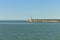 The pier of Pesaro harbor with breakwater cliffs, a colored wall and a small red lighthouse Italy, Europe