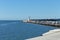 The pier of Pesaro harbor with breakwater cliffs, a colored wall and a small red lighthouse Italy, Europe