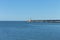 The pier of Pesaro harbor with breakwater cliffs, a colored wall and a small red lighthouse Italy, Europe