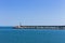 The pier of Pesaro harbor with breakwater cliffs, a colored wall and a small red lighthouse Italy, Europe