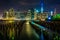 Pier pilings and the Manhattan skyline at night, seen from Brook