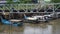 At the pier in a poor fishing village, a fisherman scoops water from a leaky boat.