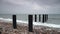 Pier posts in the ocean on stormy day