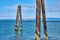 Pier remnants in San Francisco Bay framing Alcatraz Island with distant shoreline