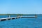 Pier on the river bank. A large flock of seagulls. Summer day