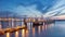 Pier in river with container terminal on background at twilight