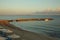 Pier in the sea at dawn with motor boats