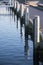 Pier shore at the marina with wooden bollards and blue sea, vert