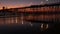 Pier silhouette Oceanside California USA. Ocean tide tropical beach. Summertime gloaming atmosphere.