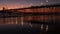 Pier silhouette Oceanside California USA. Ocean tide tropical beach. Summertime gloaming atmosphere.