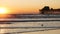 Pier silhouette at sunset, California USA, Oceanside. Ocean tropical beach. Seagull bird near wave