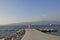 Pier with statue in Postira harbor with mountains in background, picture from Brac Island in Croatia.