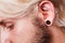 Pierced man ear, black plug tunnel, industrial and rook