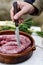 Piercing a raw pork meat sausage before to cook it