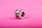 piercing, silver ear tunnel on pink background close-up