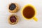 Pies with blueberries, cowberries and tea in yellow cup