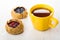 Pies with blueberries, cowberries, tea in yellow cup on table
