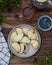 Pies with blueberries on a plate on a wooden table, top view.