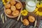 Pies or buns and a mug of homemade farm fresh milk, sunflower, baked goods on a wooden background 7