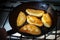 Pies fried in a black cast iron skillet.