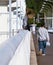 A pigeon flies away while the man is walking on the street carrying a plastic bag. Street photography image.