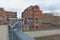 Pigeon perched on a handrail with red brick buildings in the background radial motion blur