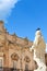 Pigeon sitting on marble statue belonging to Cathedral of Syracuse on Piazza Duomo in Syracuse, Sicily, Italy. Pigeon droppings