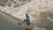 Pigeon sitting on the weir above a storming river