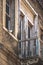 Pigeon standing by the windowsill, rustic doors and balcony