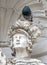 The pigeon stands on the head of a historic sculpture