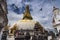 Pigeons fly around the Swayambhunath stupa , Kathmandu , Nepal