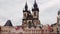 Pigeons fly over empty main old town square of Prague, on background of gothic costel.