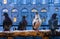 Pigeons sit on a wooden railing in the city center, feathered