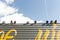 Pigeons sitting on a metal fence against a blue sky