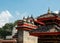 Pigeons sitting on the traditional Nepalese brown tiled roof of an ancient Hindu temple.