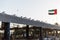 Pigeons stand in the roof of open air seafood market with waving UAE flag near Palm Deira metro station in Dubai