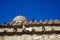 Pigeons in white, black and grey color on terracotta roof tile of old classic little church in earth tone natural stone wall