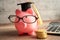 Pigging bank wearing eyeglass with coin, calculator and graduation hat, saving bank education concept