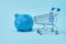 Piggy bank with basket on a blue background. online shopping, saving your family budget