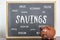 Piggy bank and blackboard with the word savings. Saving money and life expenses concept